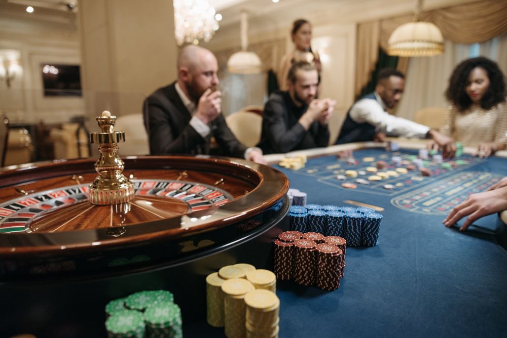 Meja roulette dengan tumpukan chip kasino di studio live casino
