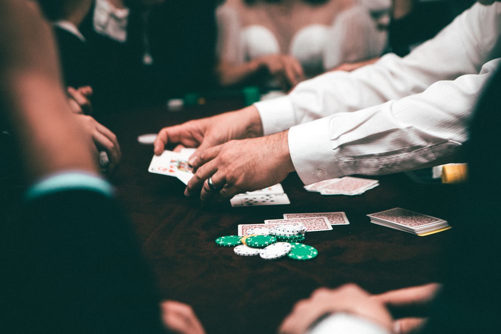 Pemain poker menumpuk chip di atas meja saat pertandingan